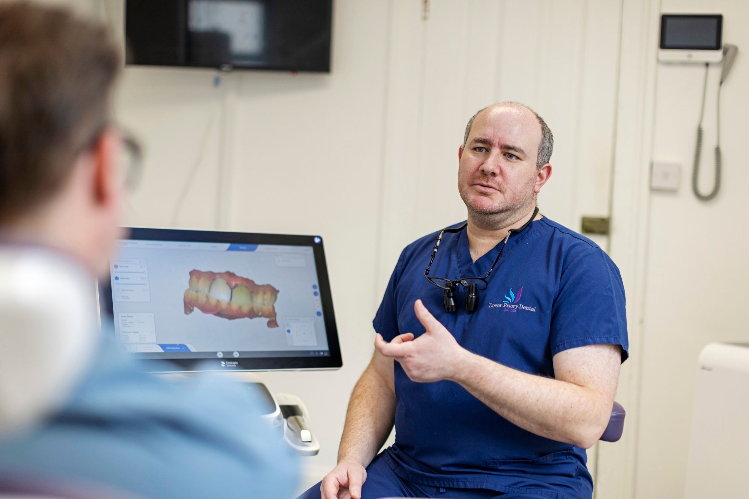 Dr Theo Mechteridis talking a patient through a digital scan